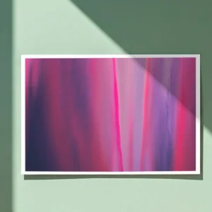 A close-up of an unframed abstract poster print on a light green wall. Sunlight casts a diagonal shadow across the top right of the artwork